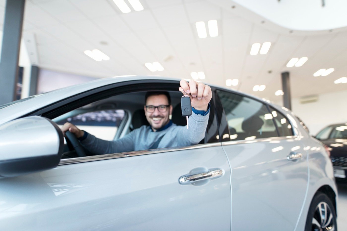 Comprador recebendo a chave do carro novo